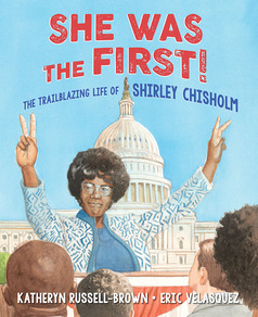 Cover of She Was the First!: The Trailblazing Life of Shirley Chisholm showing Shirley flashing peace signs at a podium with the US Capitol in the background and an audience in front of her 