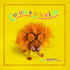 Colores de la vida cover showing a carving of a lion in front of a yellow backdrop