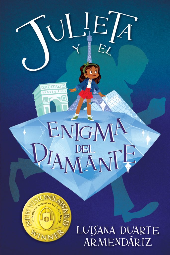 Cover of Julieta y el enigma del diamante, showing Julieta standing curiously on top of a giant floating diamond, with a miniature of the Louvre museum as part of the top of the diamond. A dark blue and the silhouette of a thief are behind her.