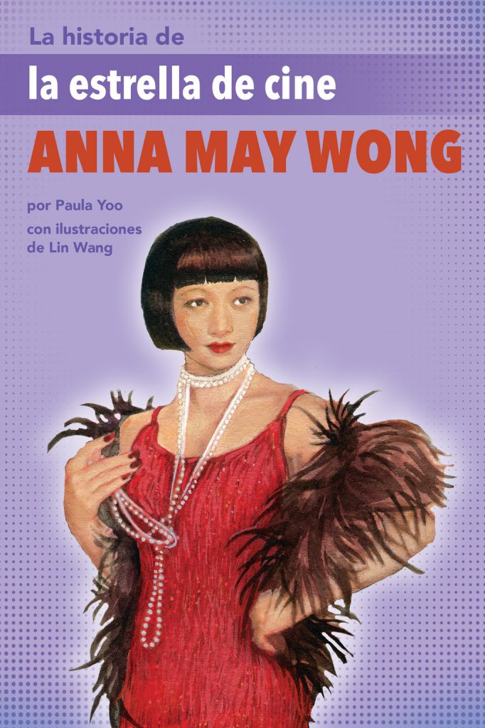 Cover of La historia de la estrella de cine Anna May Wong, showing Anna posed front and center, sporting short dark hair with blunt bangs, wearing a red dress and a brown feather boa draped around her shoulders, as well as a long string of pearls around her neck. The background is purple.